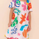 Vestido infantil com estampa colorida de formas geométricas e mangas amplas
