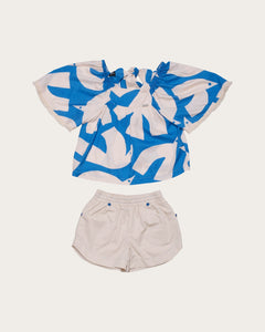 Conjunto feminino infantil com blusa de mangas amplas estampada em azul e branco e short claro
