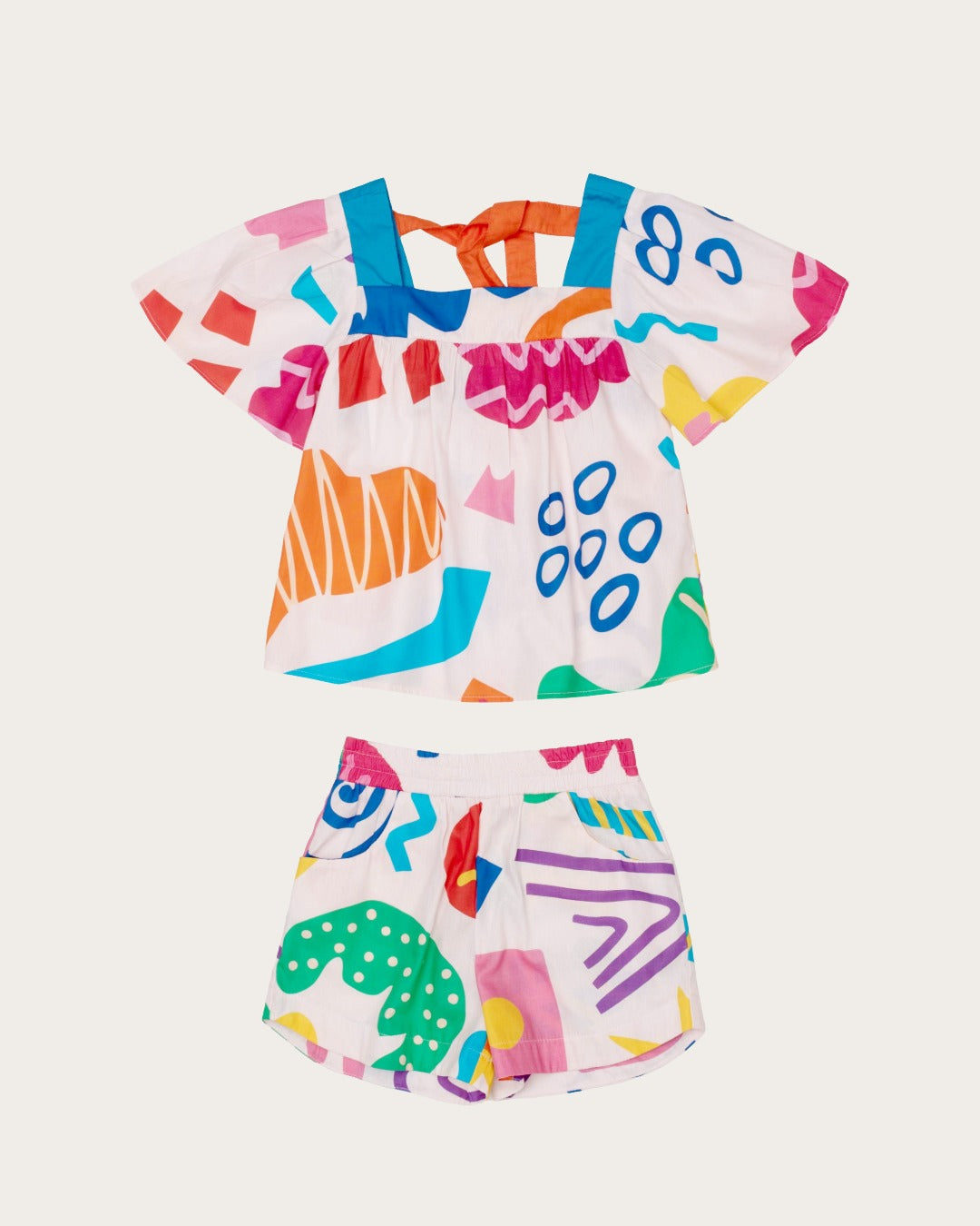 Conjunto infantil feminino com blusa de mangas amplas e shorts, estampa geométrica colorida