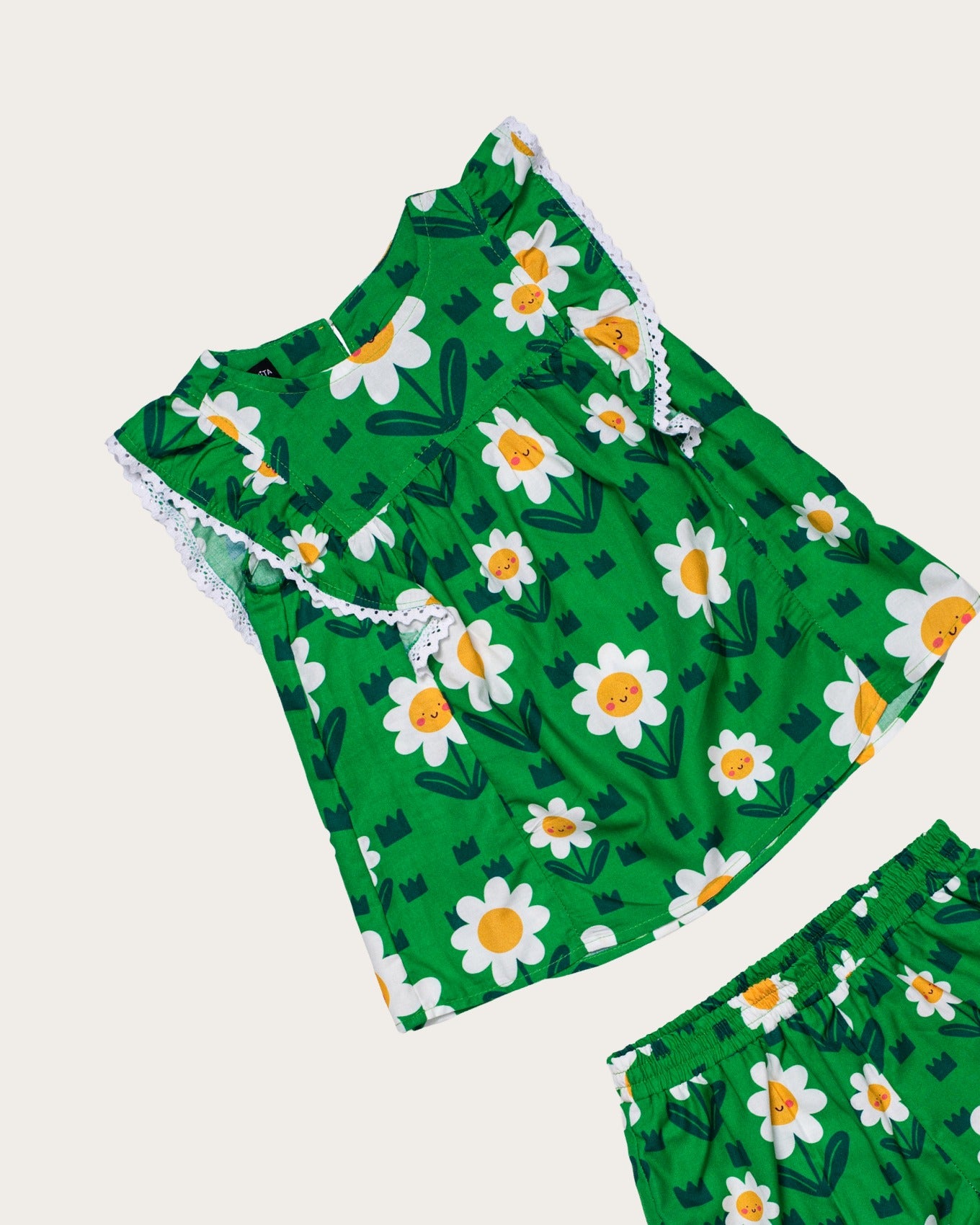 Conjunto infantil feminino com blusa verde e short, estampa de flores brancas e detalhe em renda
