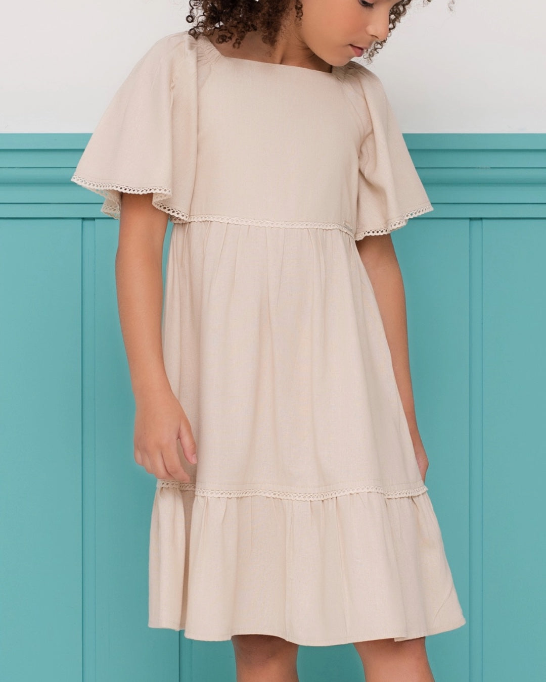 Vestido infantil com mangas amplas e saia rodada em tom neutro