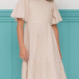 Vestido infantil com mangas amplas e saia rodada em tom neutro