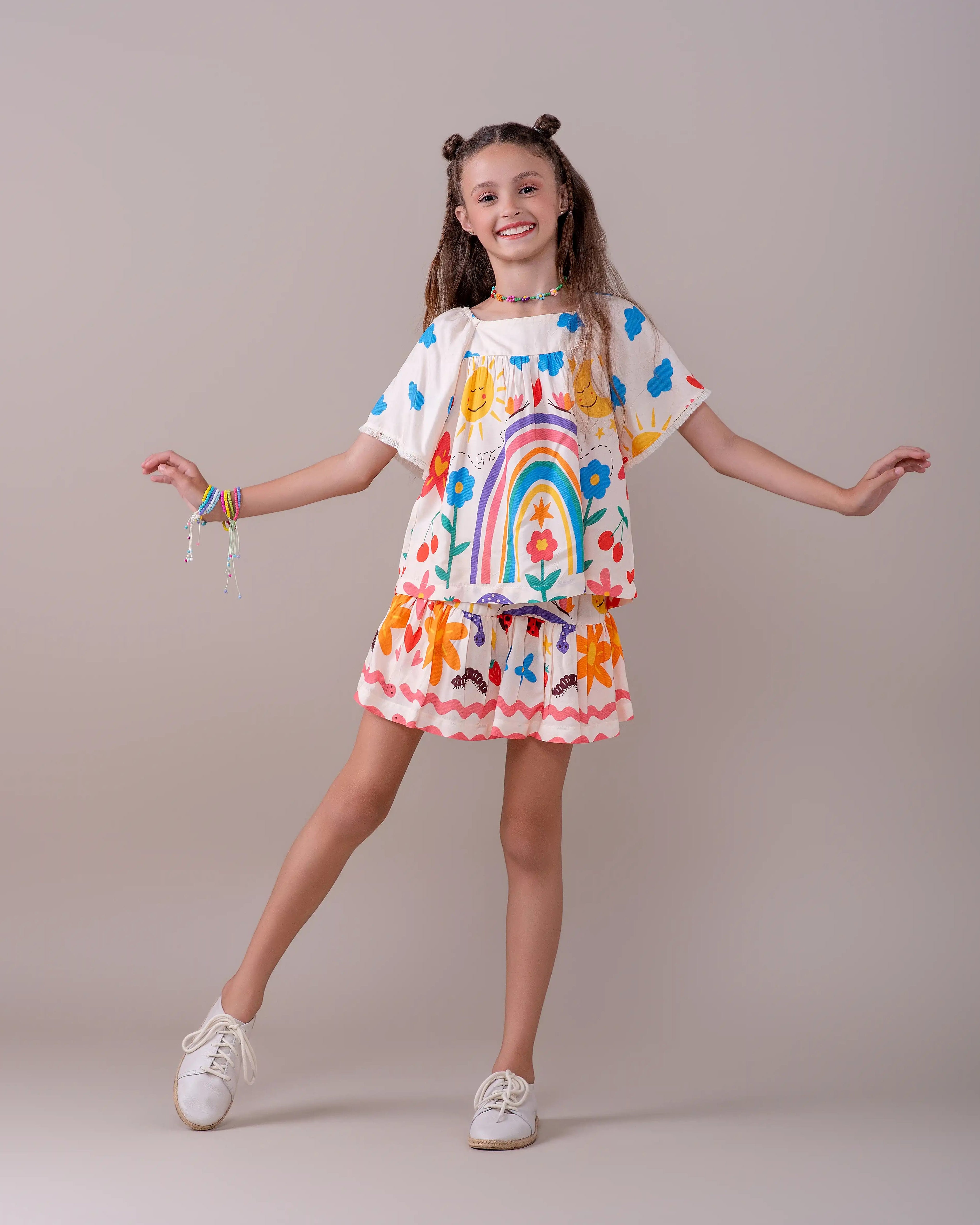 Conjunto infantil feminino com blusa de mangas bufantes e saia rodada, estampa colorida de arco-íris e flores