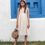 Vestido feminino infantil com alças largas e botões frontais, tom neutro e saia ampla