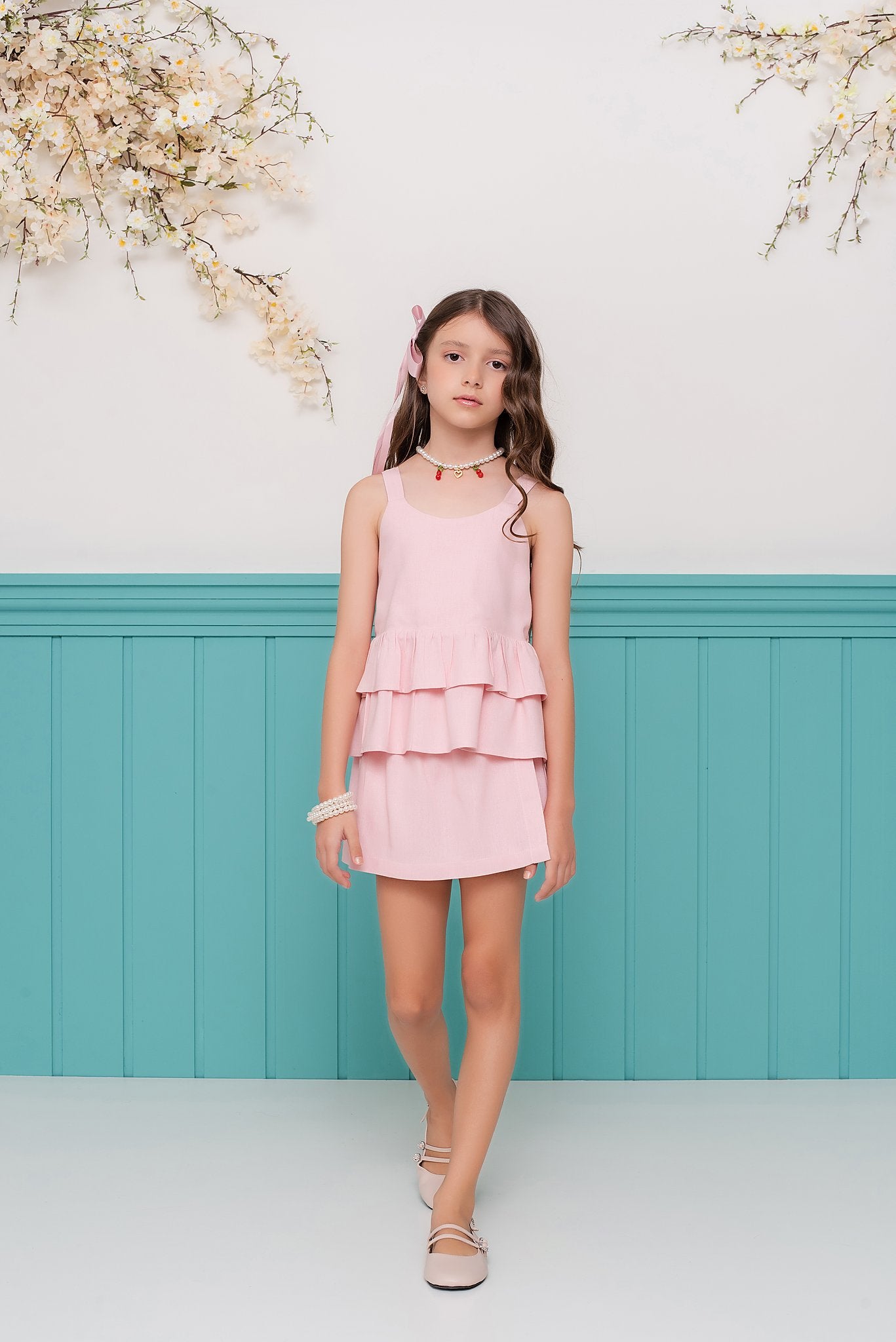 Conjunto feminino infantil com blusa de alças largas e saia curta, detalhes em camadas