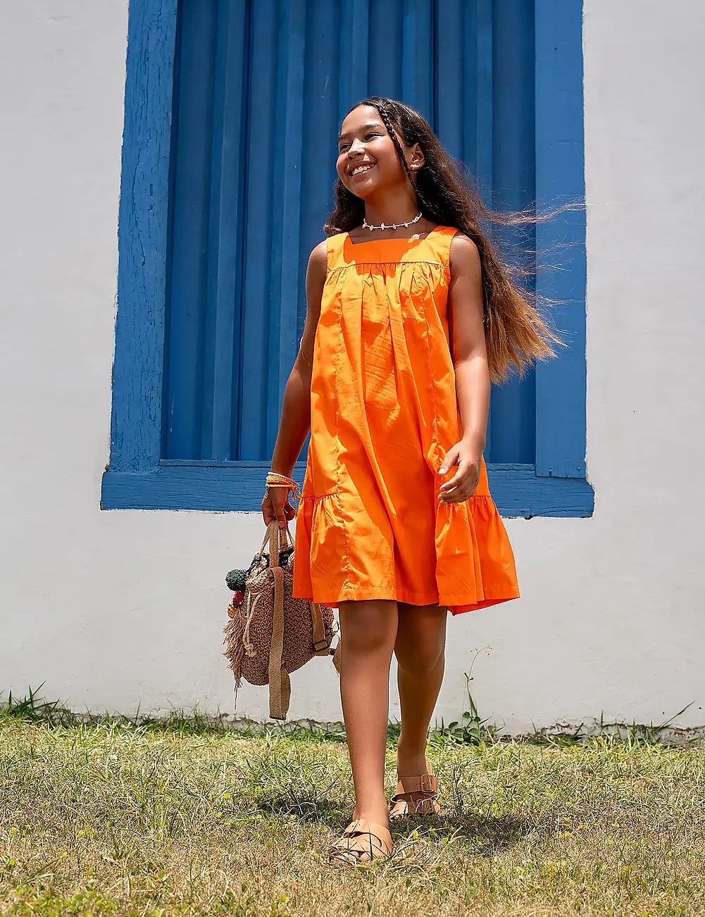 Vestido laranja infantil com alças largas e saia rodada, acabamento em babados