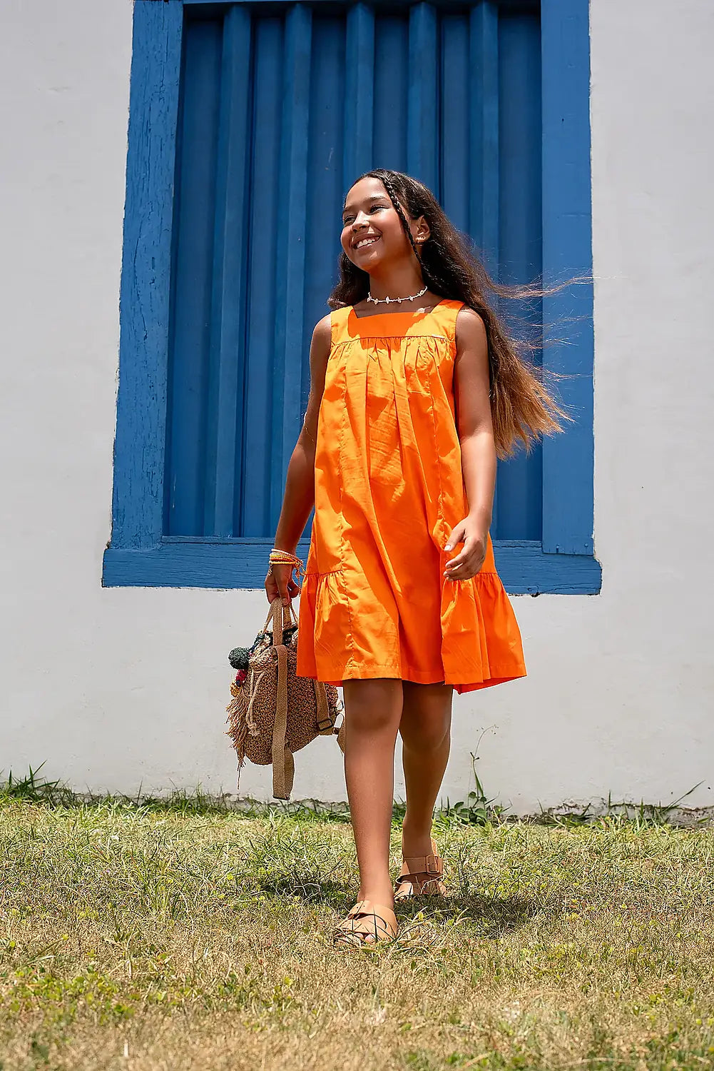 Vestido laranja infantil com alças largas e saia rodada, acabamento em babados