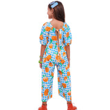 Macacão infantil com estampa de bergamotas em fundo azul xadrez e mangas bufantes