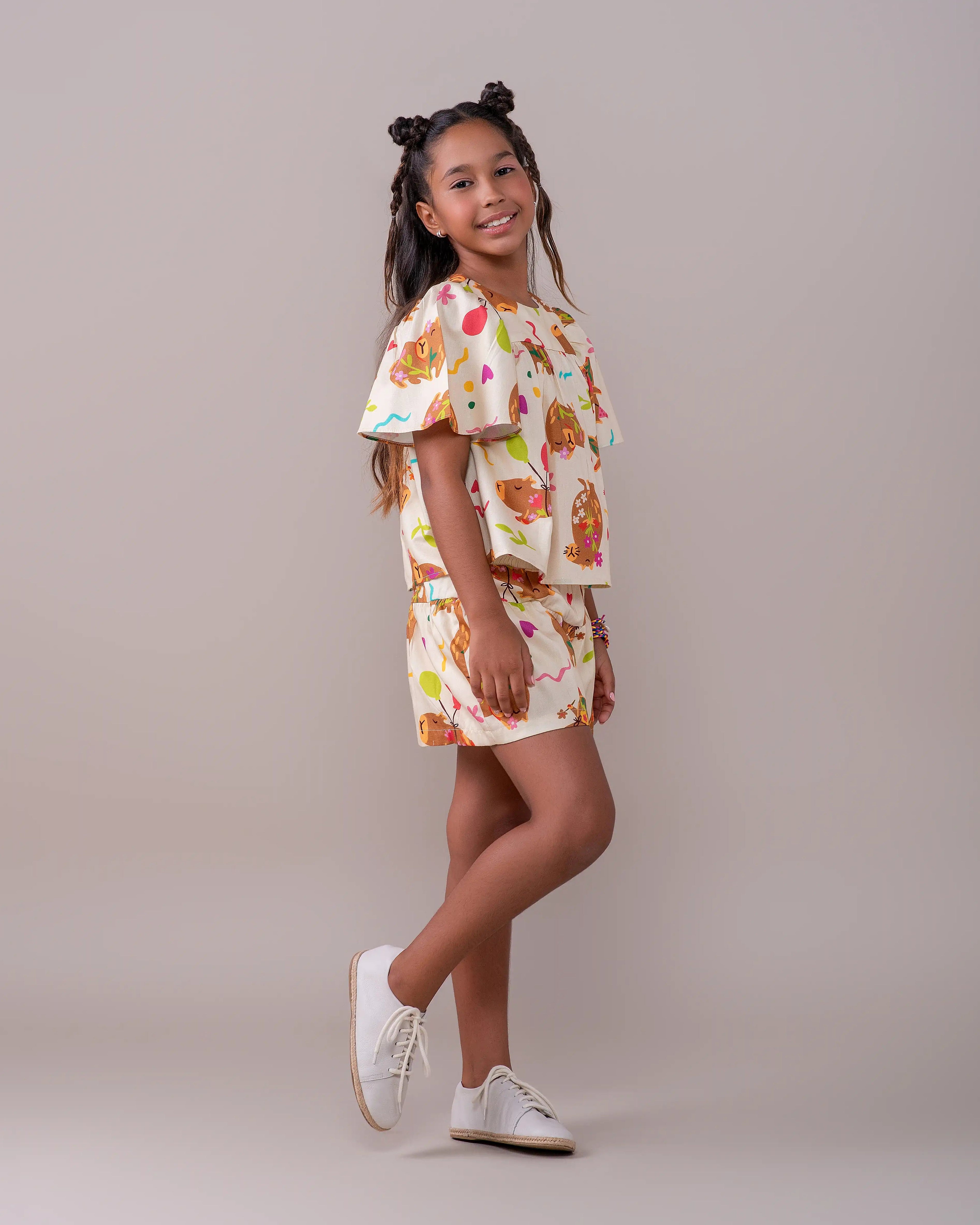 Conjunto infantil feminino com blusa de mangas amplas e saia, estampa de capivaras e balões coloridos