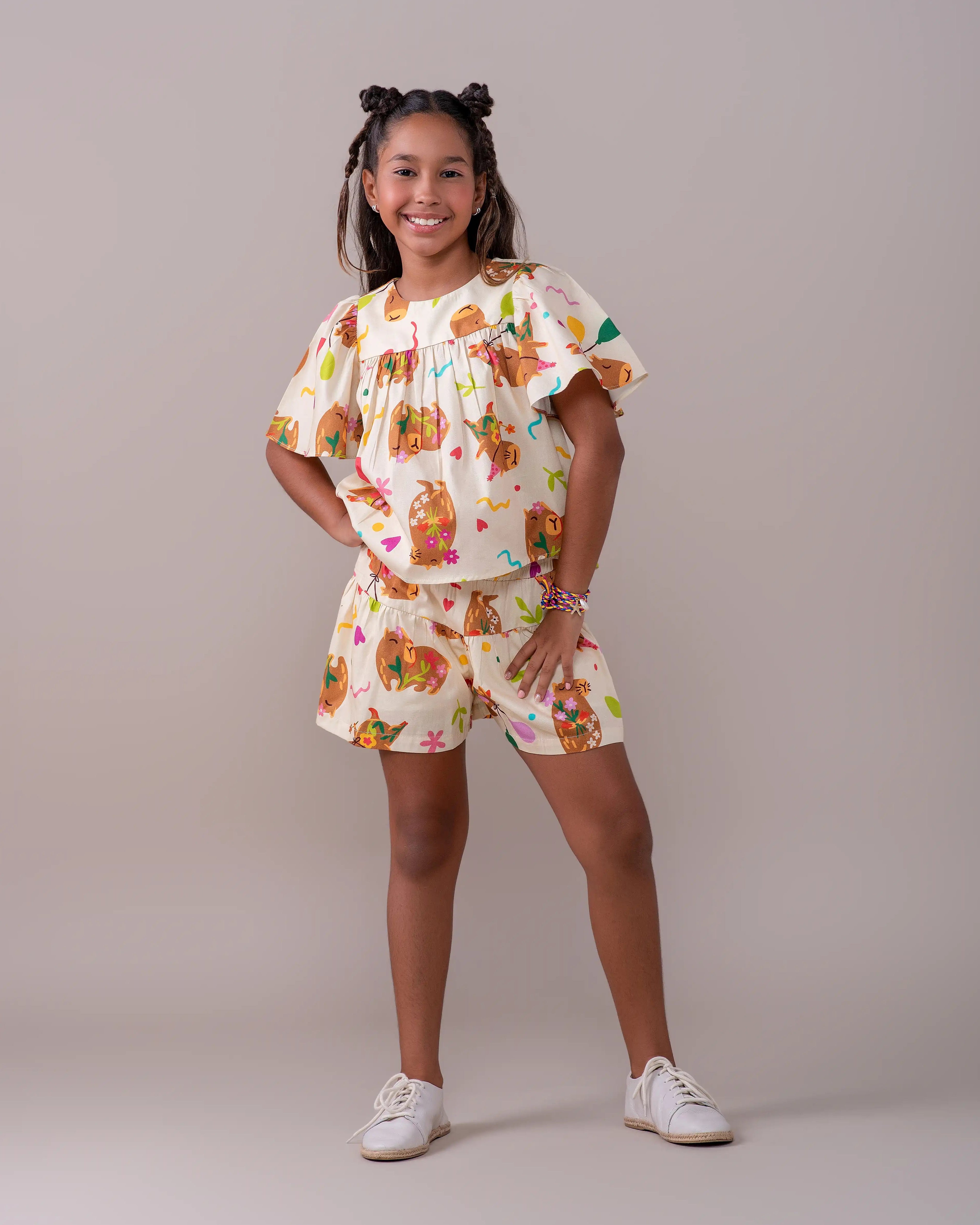 Conjunto infantil feminino com blusa de mangas amplas e saia, estampa de capivaras e balões coloridos