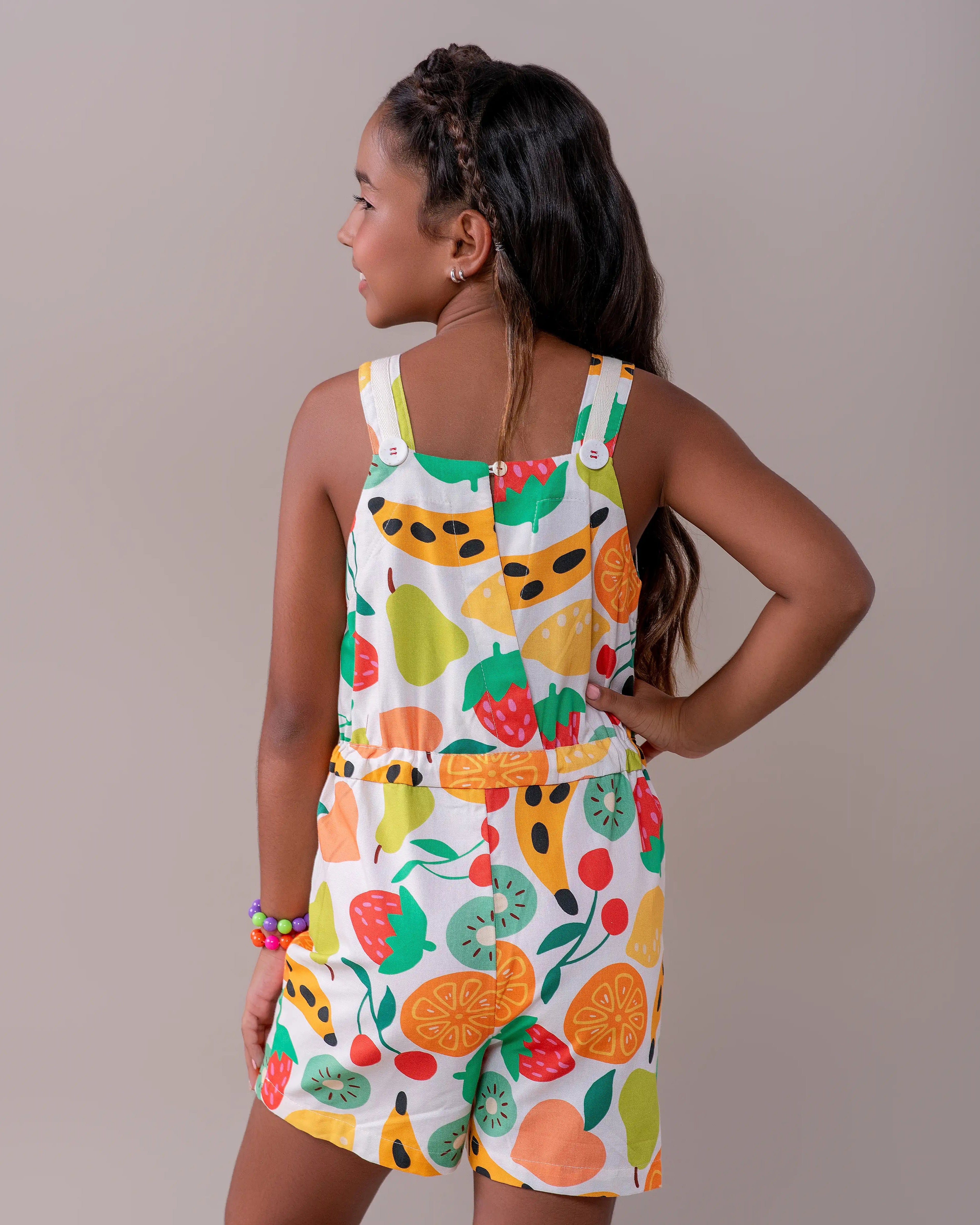 Jardineira infantil com estampa de frutas coloridas e alças largas
