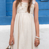 Vestido feminino infantil com alças largas e botões frontais, tom neutro e saia ampla