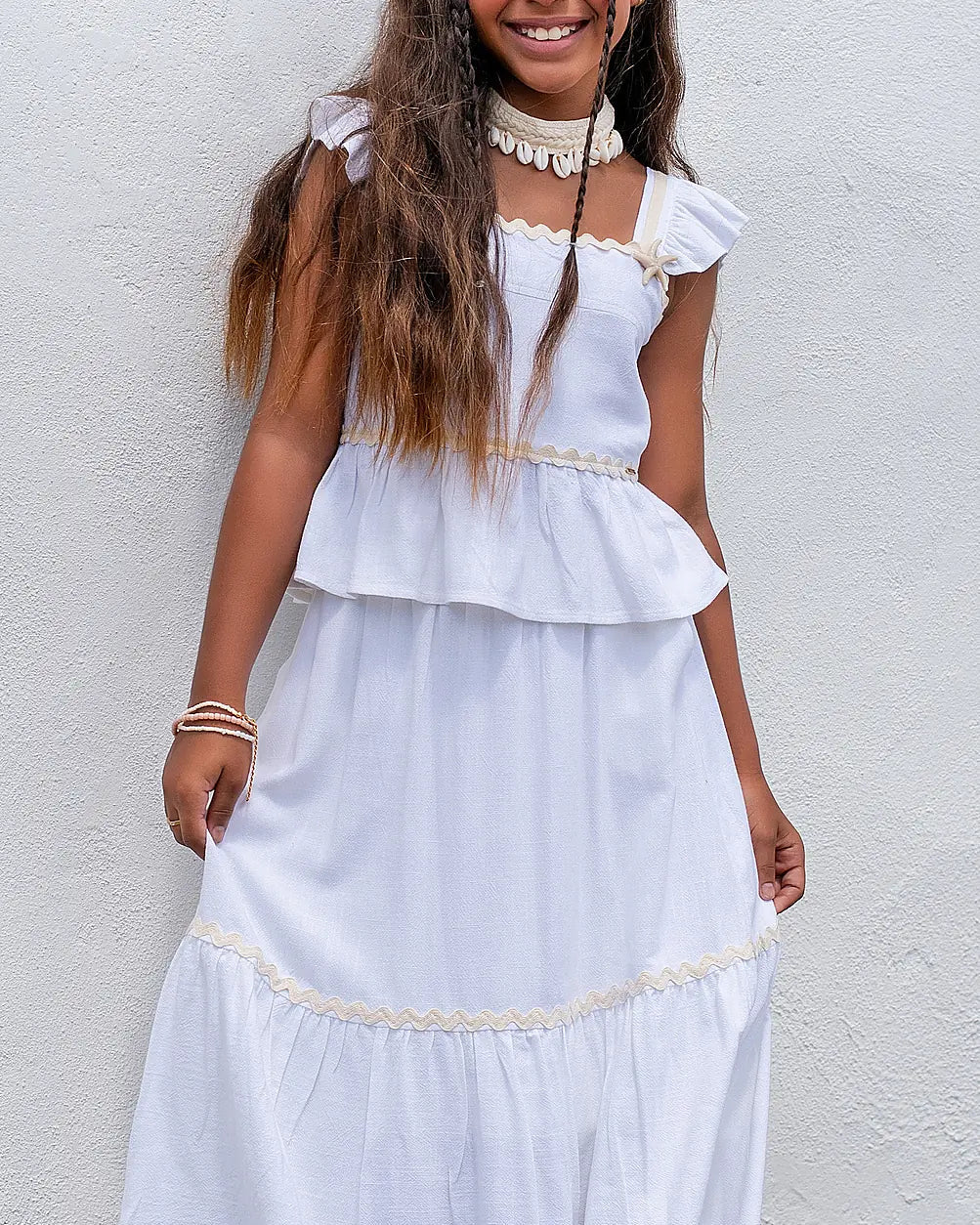 Conjunto feminino infantil com blusa de alças e saia rodada brancas, detalhes em babados