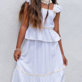 Conjunto feminino infantil com blusa de alças e saia rodada brancas, detalhes em babados