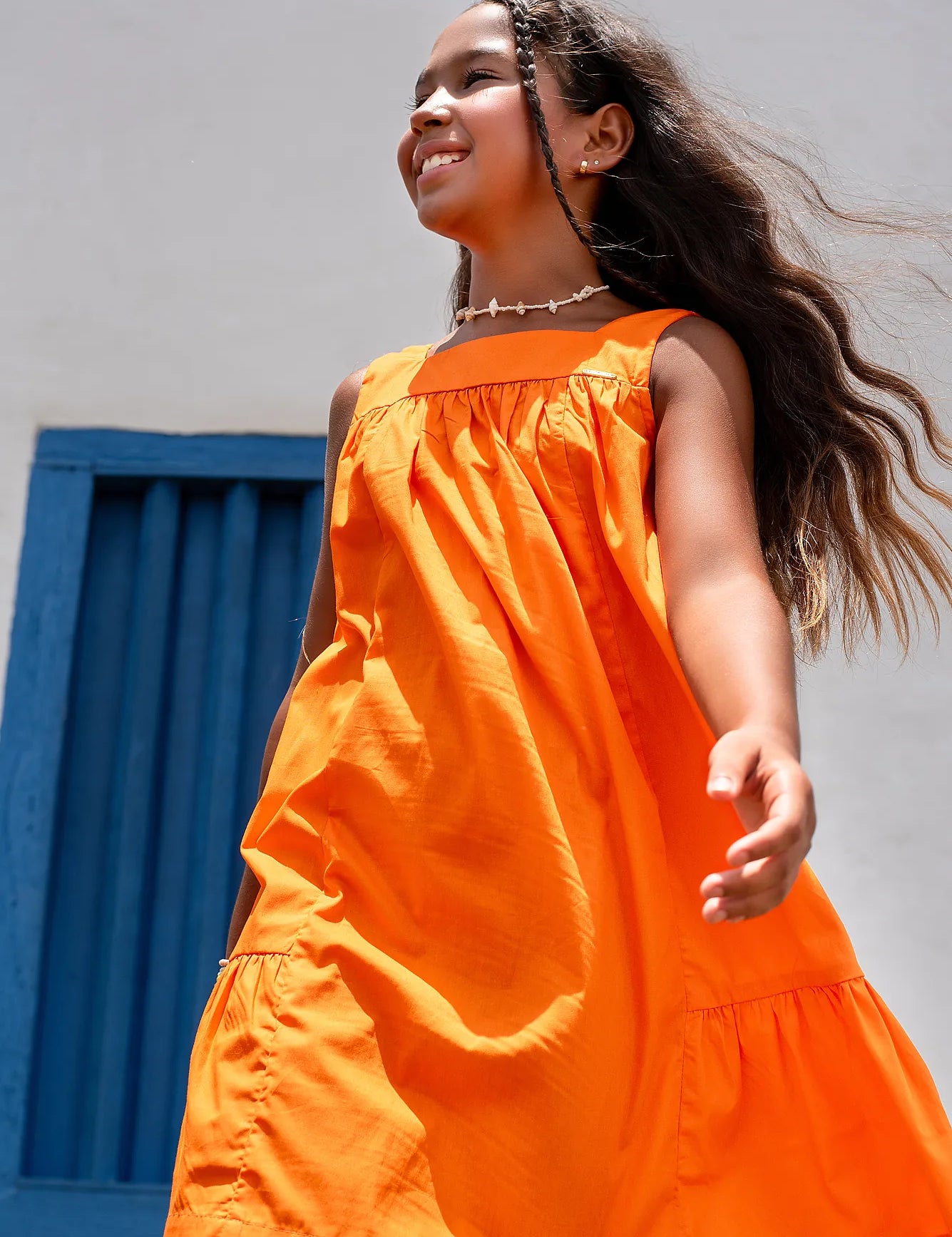 Vestido laranja infantil com alças largas e saia rodada, acabamento em babados