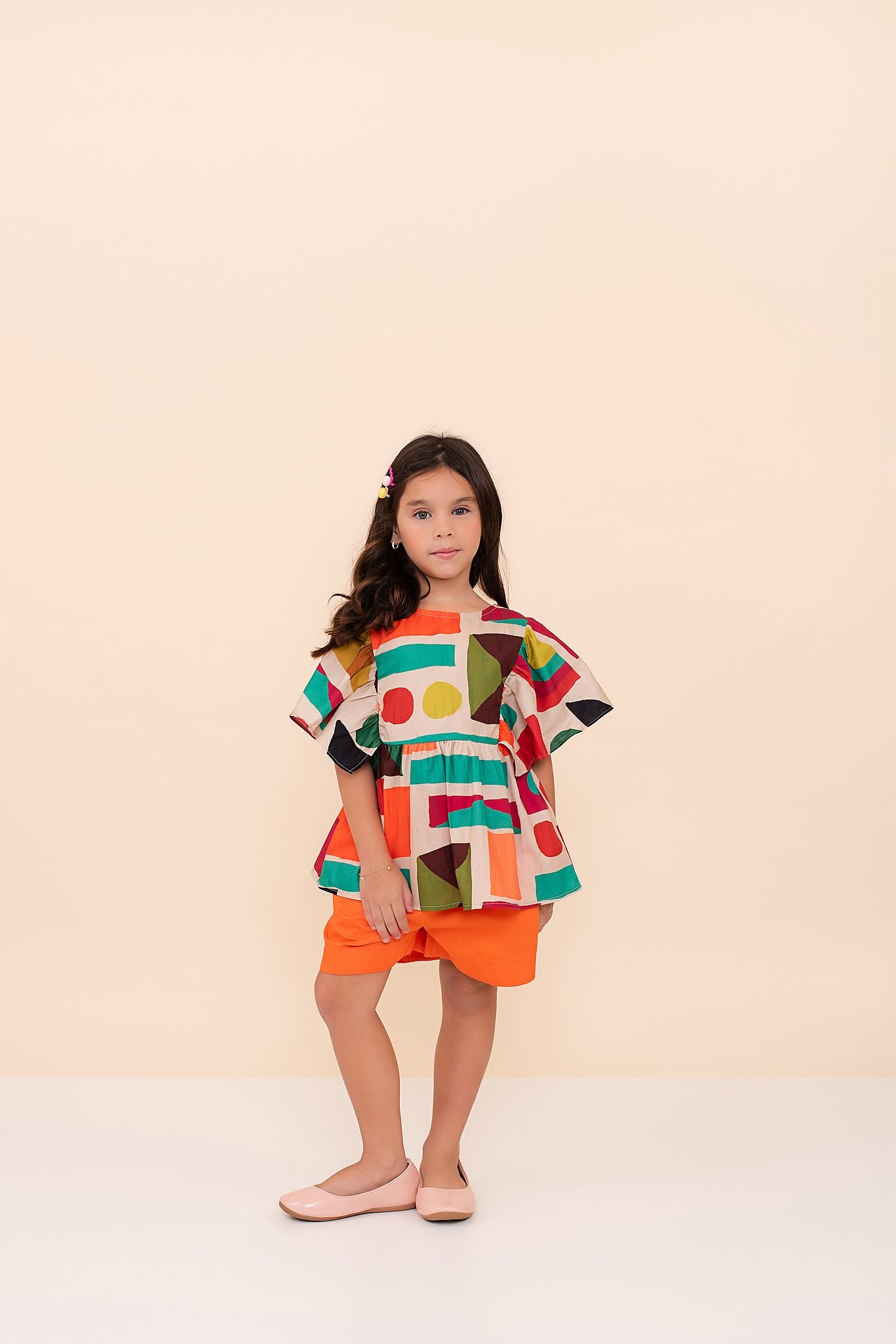 Conjunto feminino infantil com blusa estampada em formas geométricas e short laranja