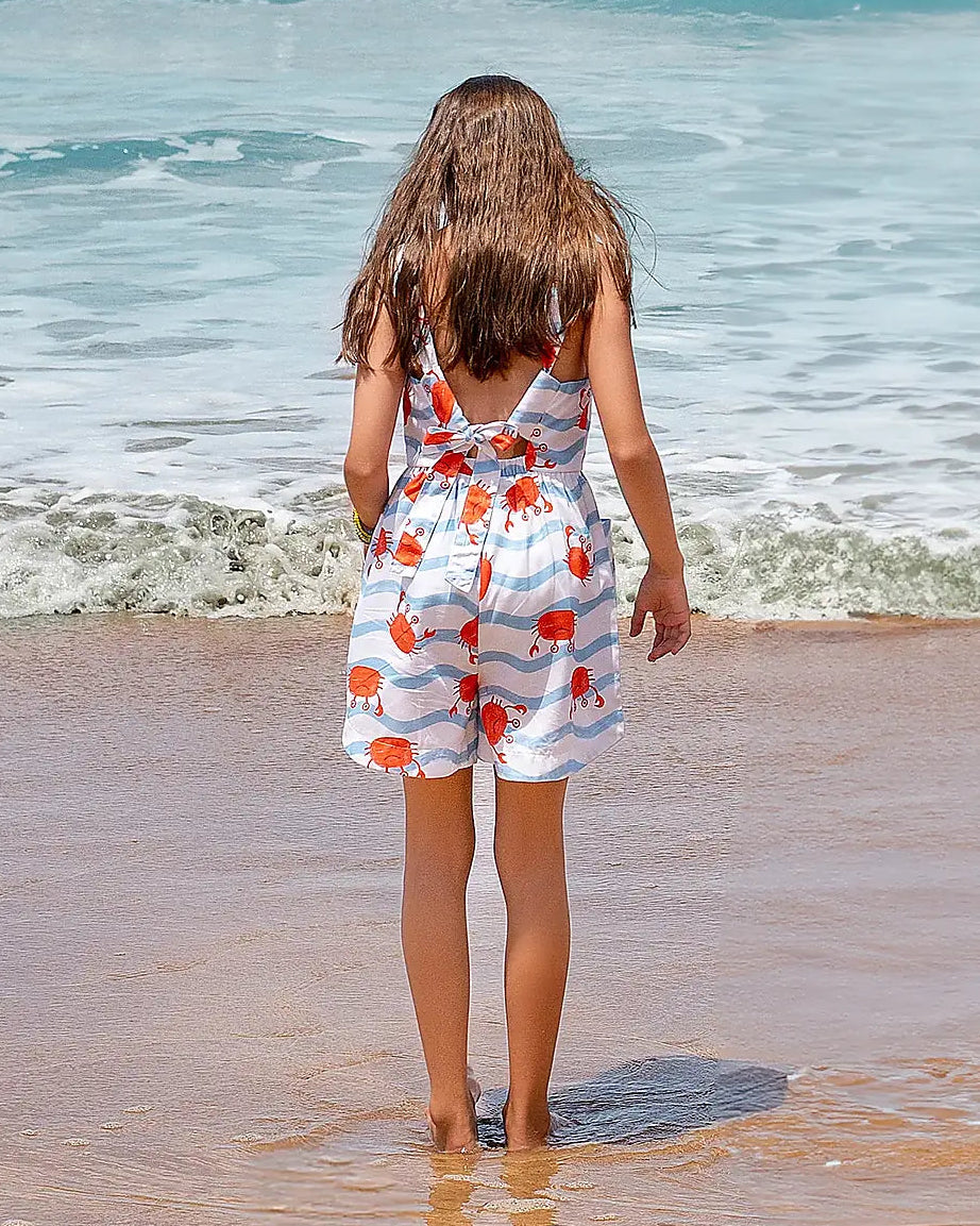 Macacão infantil com estampa de caranguejos em fundo azul listrado, alças finas