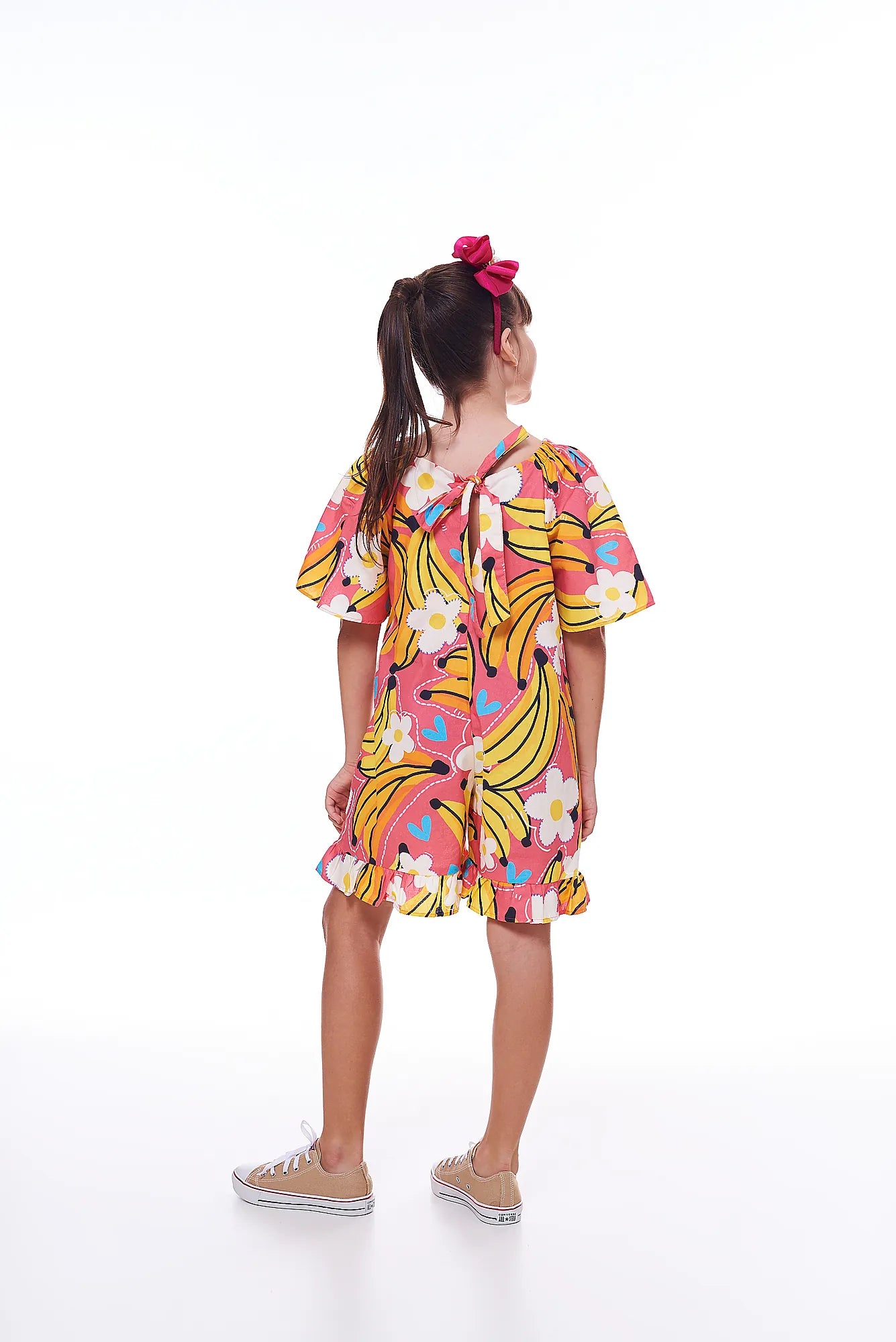 Macaco feminino infantil com estampa de bananas e flores em fundo rosa, detalhe de mangas amplas