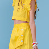 Conjunto infantil amarelo com blusa de alças largas e short leve, detalhes nas mangas